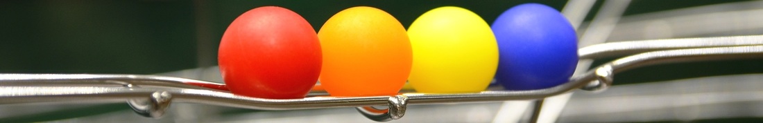 Colorful balls resting on stainless steel track.